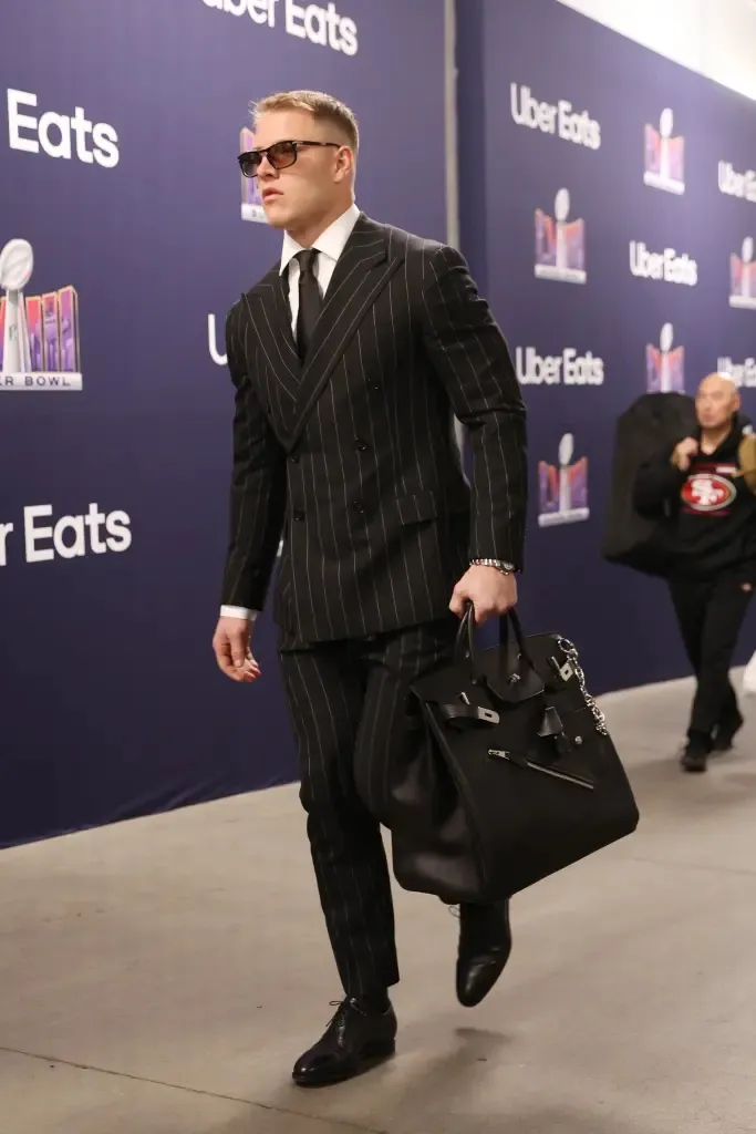 Christian McCaffrey arriving carrying a black Hermès HAC bag