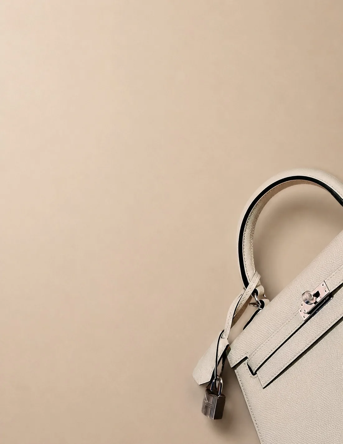 The Wealth Velocity — a cream Hermès Kelly bag